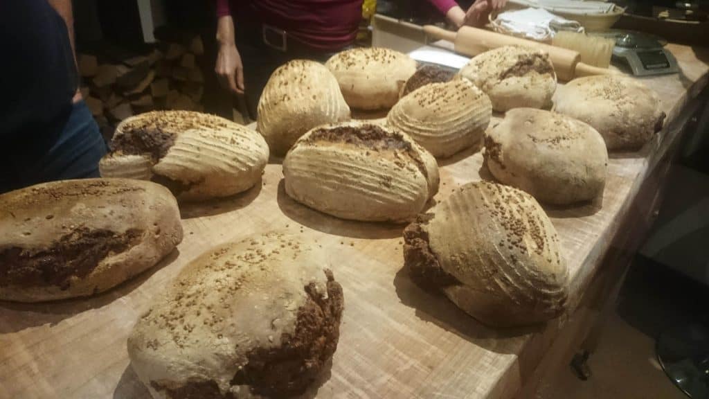 Kurt Gellner - Ein Brotbackkurs präsentiert eine Gruppe von Laiben Brot auf einer hölzernen Oberfläche. - die Feuerstellen