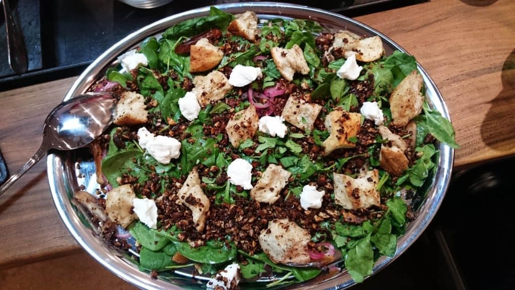 Ein Teller mit einem Salat darauf, zubereitet im Kochkurs.