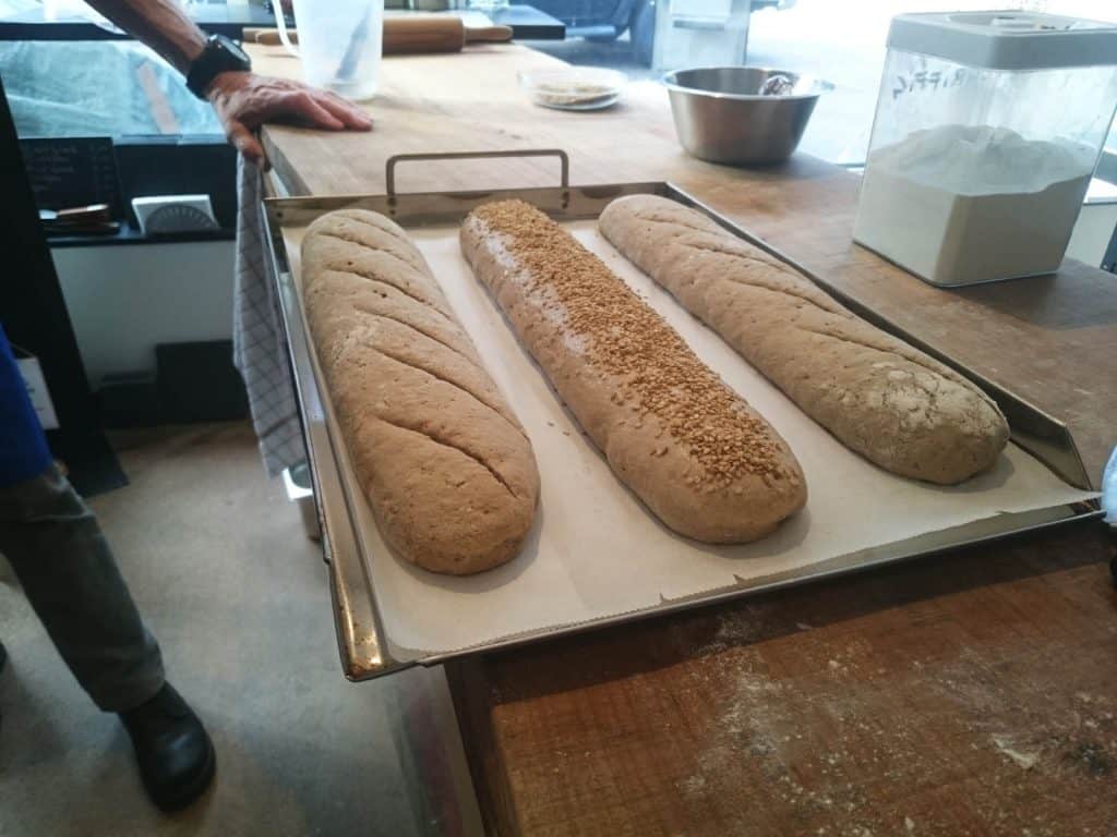 Kurt Gellner - Ein Tablett mit Brot auf einer Theke nach einem Brotbackkurs. - die Feuerstellen