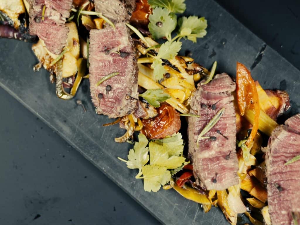 Ein Teller mit Steak aus einem Kochkurs und Gemüse darauf.